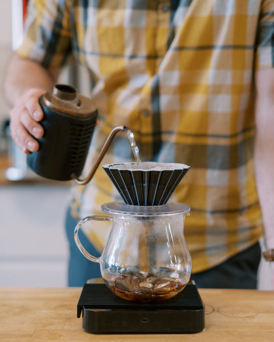 Man pouring water into Origami dripper making ice brew coffee