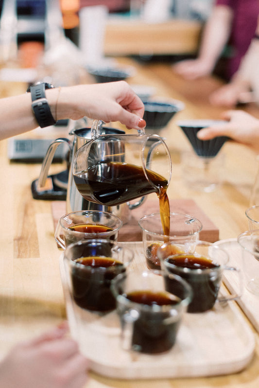 Coffee being poured into multiple coffee cups